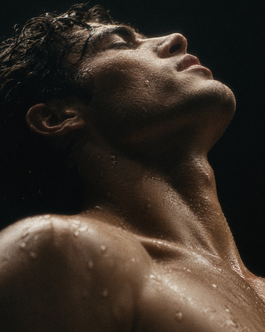 Man with a bare upper body against a dark background